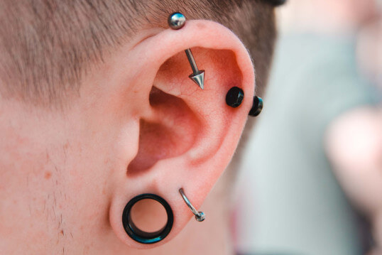 Mann mit vielen Piercings im Ohr